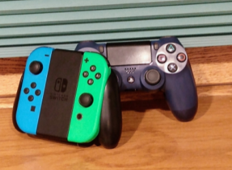 A photo of a Playstation 4 and Nintendo Switch remote.